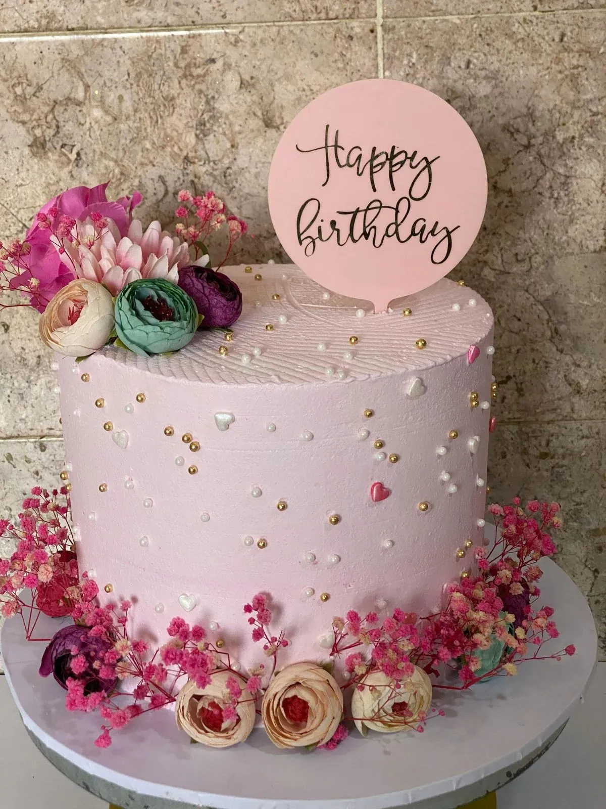 Pink round celebration cake with piped buttercream