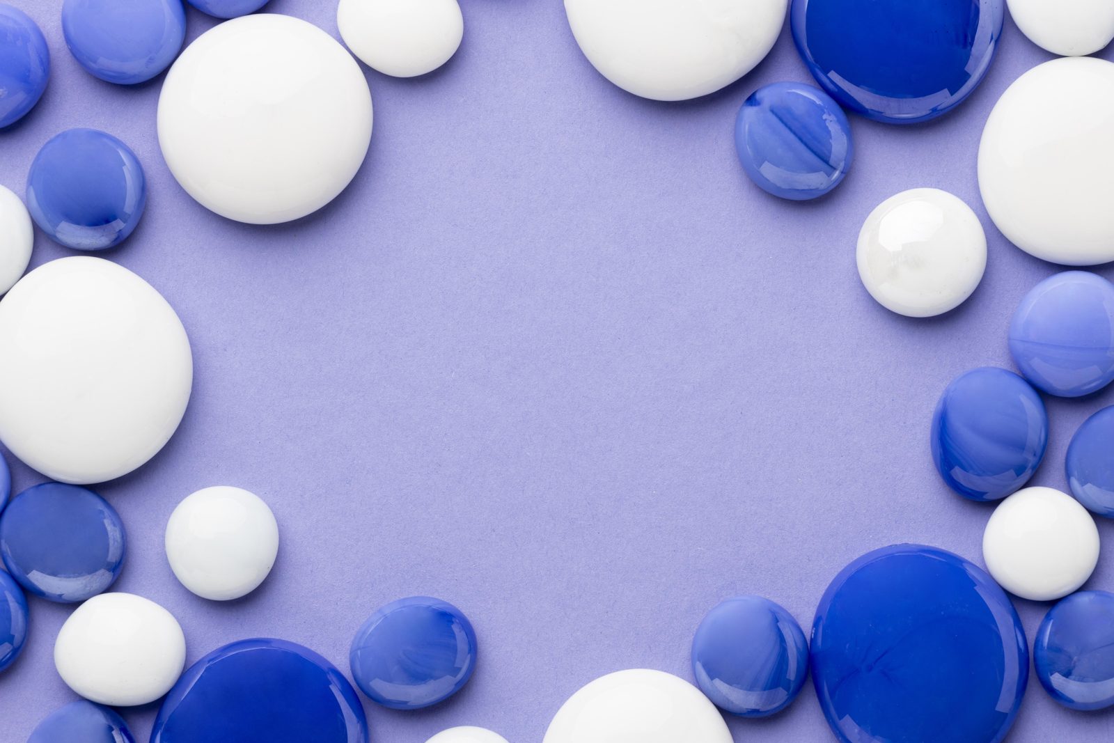 Blue and white pebbles framing a soft lavender background