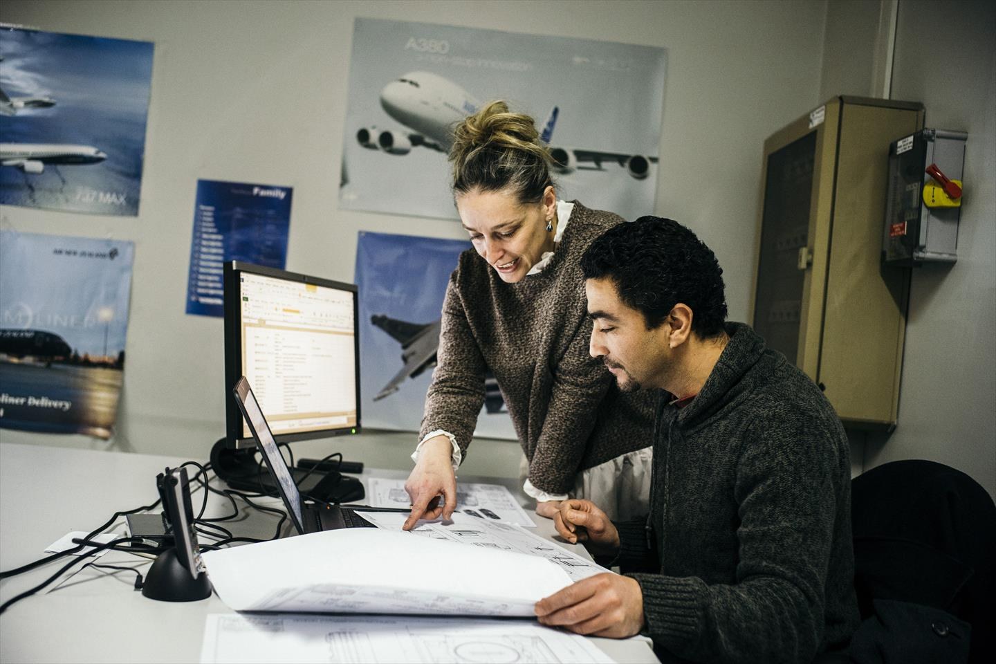 Engineers reviewing a detailed technical plan at a desk