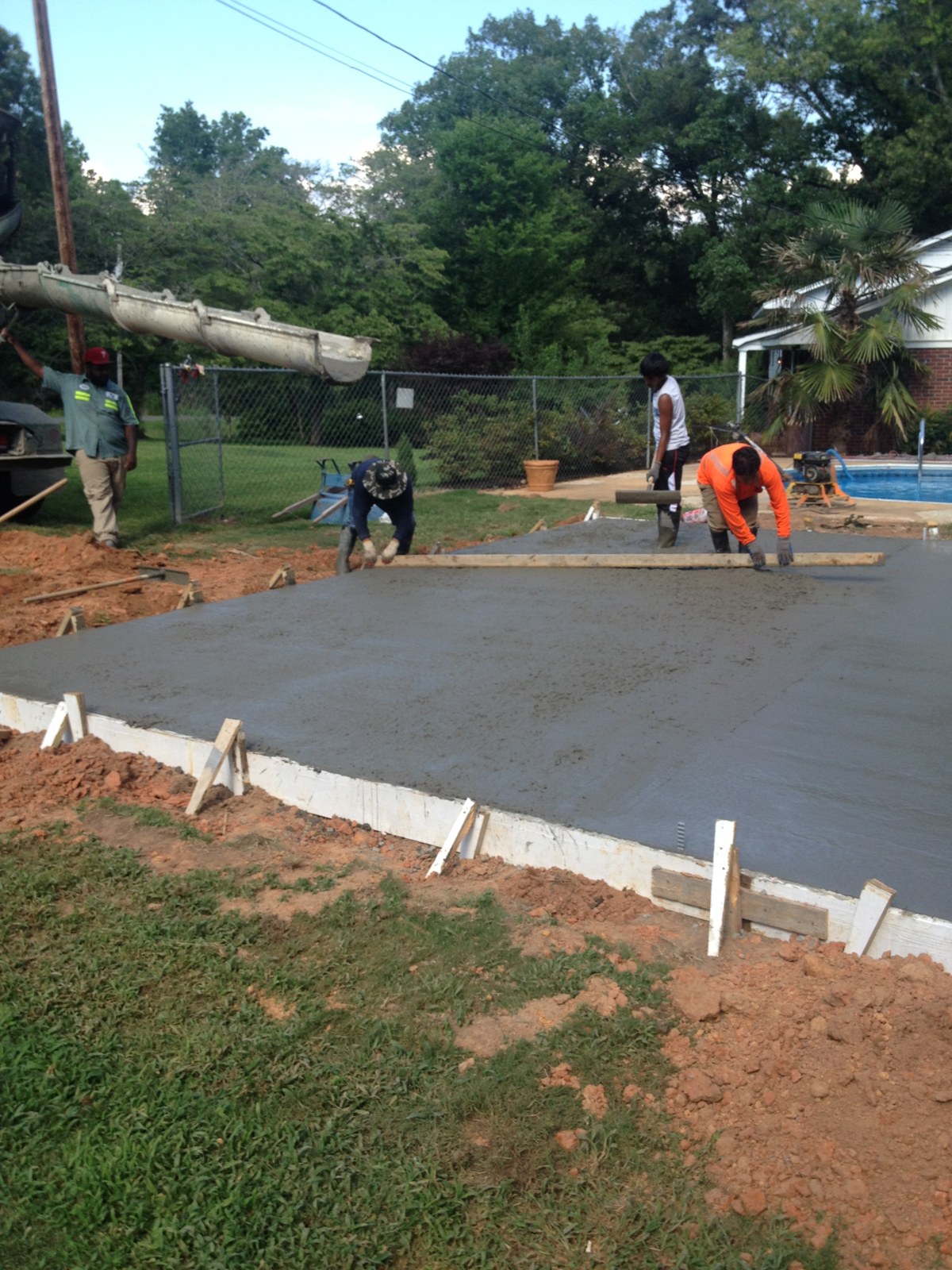 Monolithic garage foundation during concrete placement and finishing