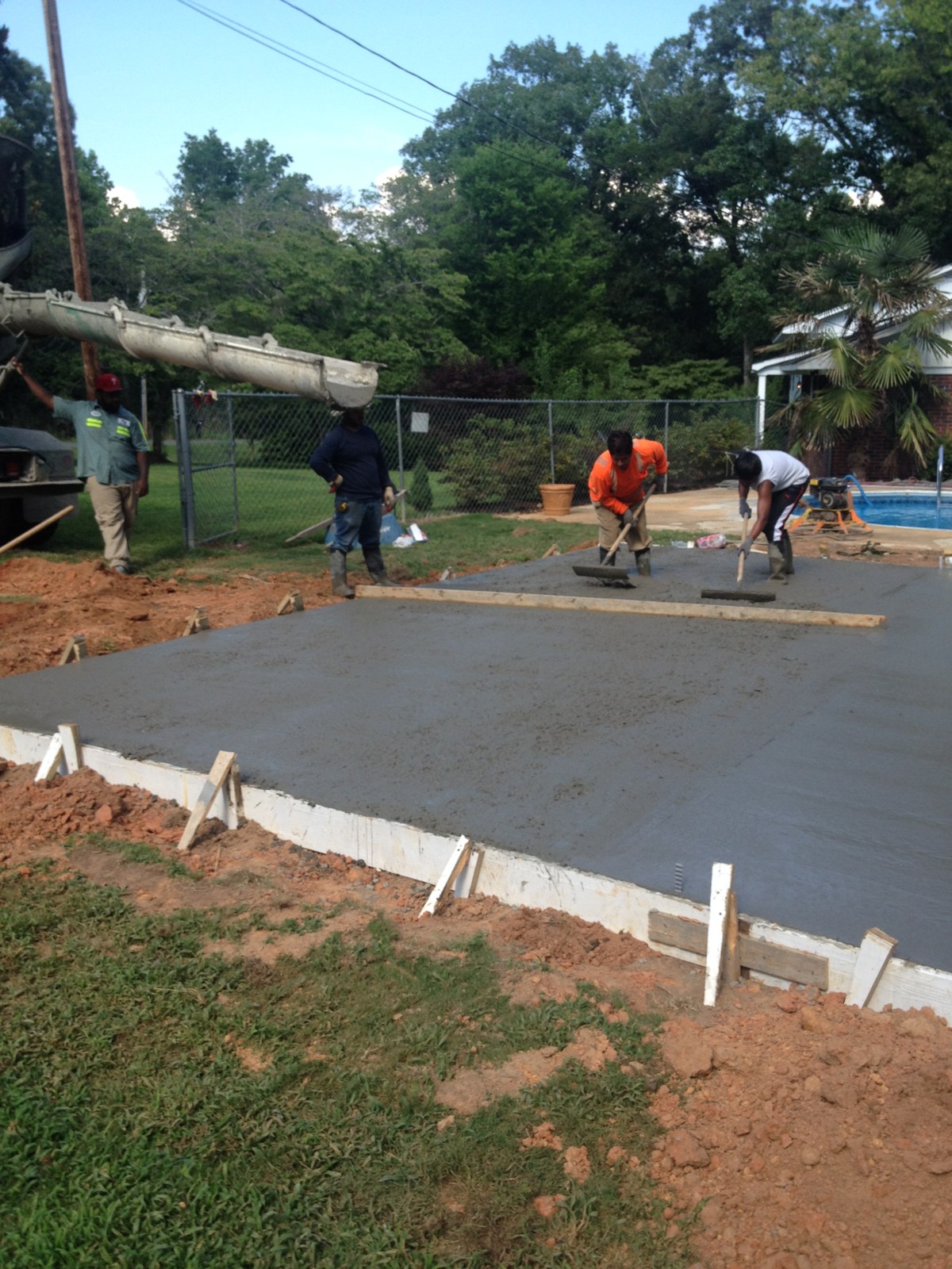 Monolithic garage foundation during concrete placement and finishing