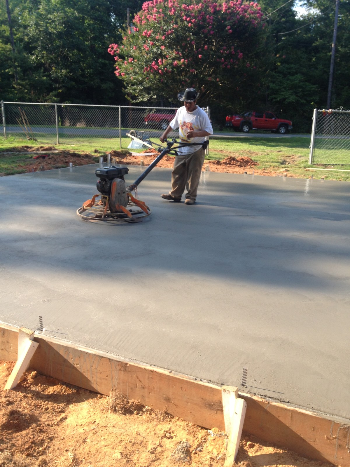 Monolithic garage foundation during concrete placement and finishing