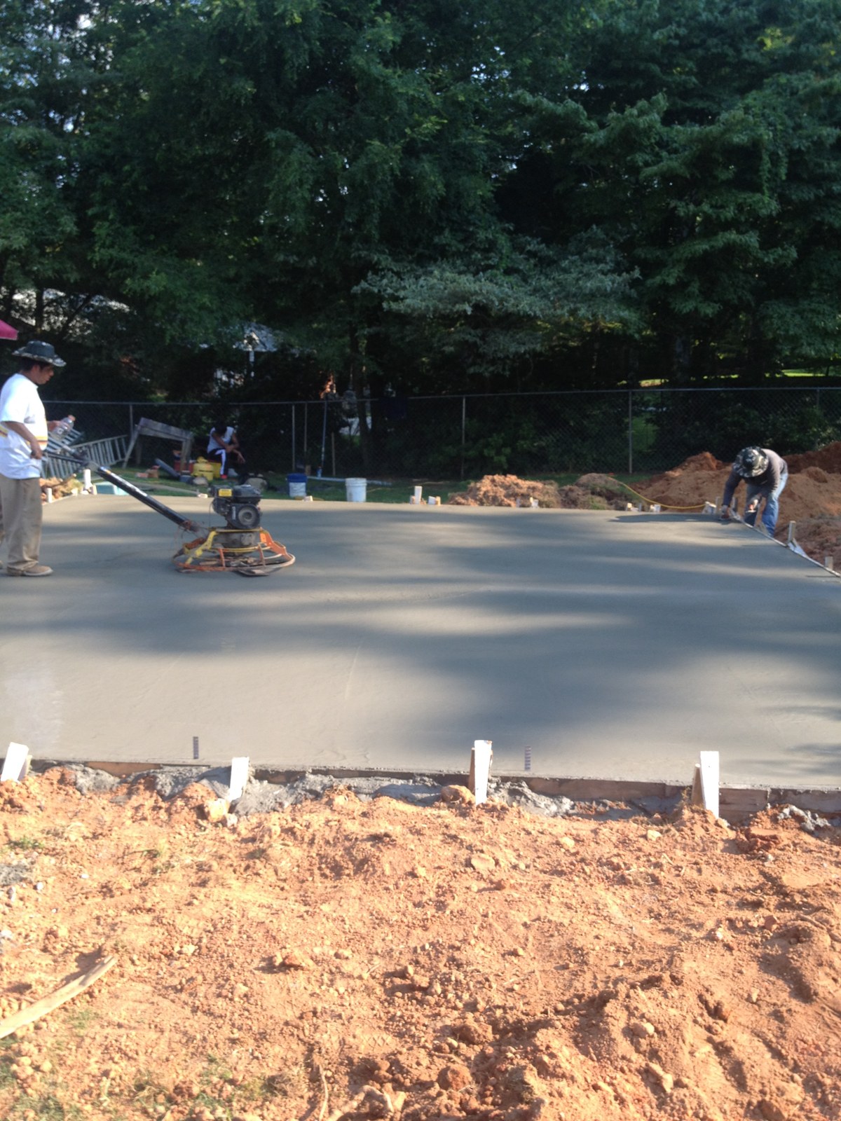 Monolithic garage foundation during concrete placement and finishing