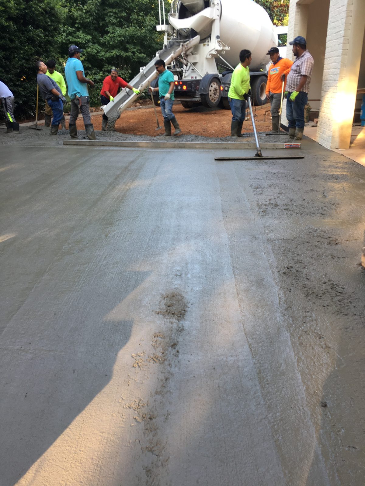 Concrete crew finishing a wide residential driveway