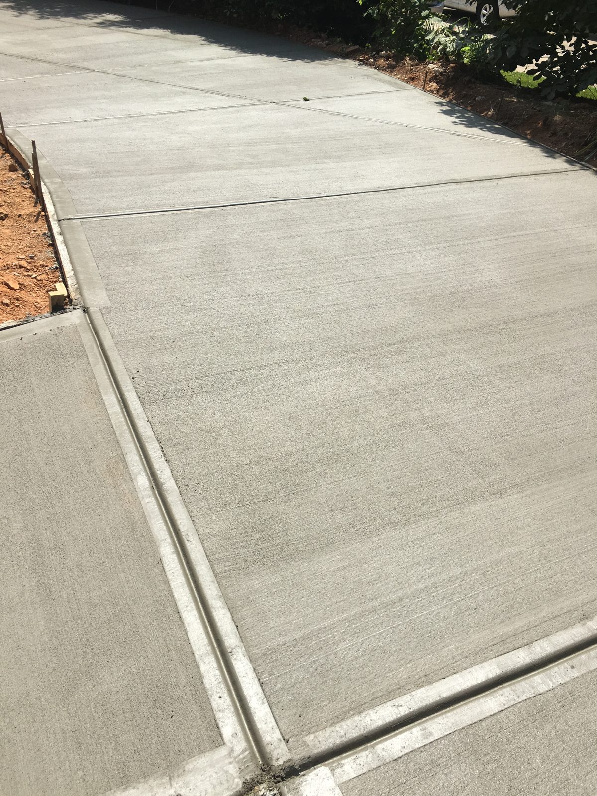 Broom-finished driveway with clean joints and a curved edge
