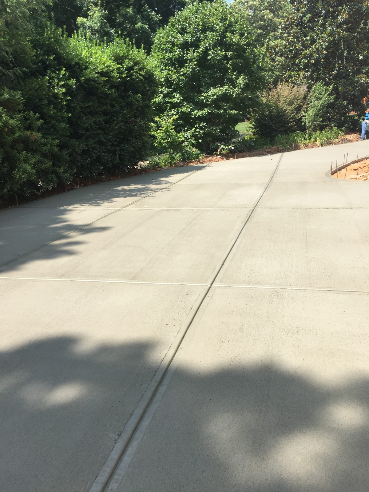 Finished residential driveway with tree shadows across the surface