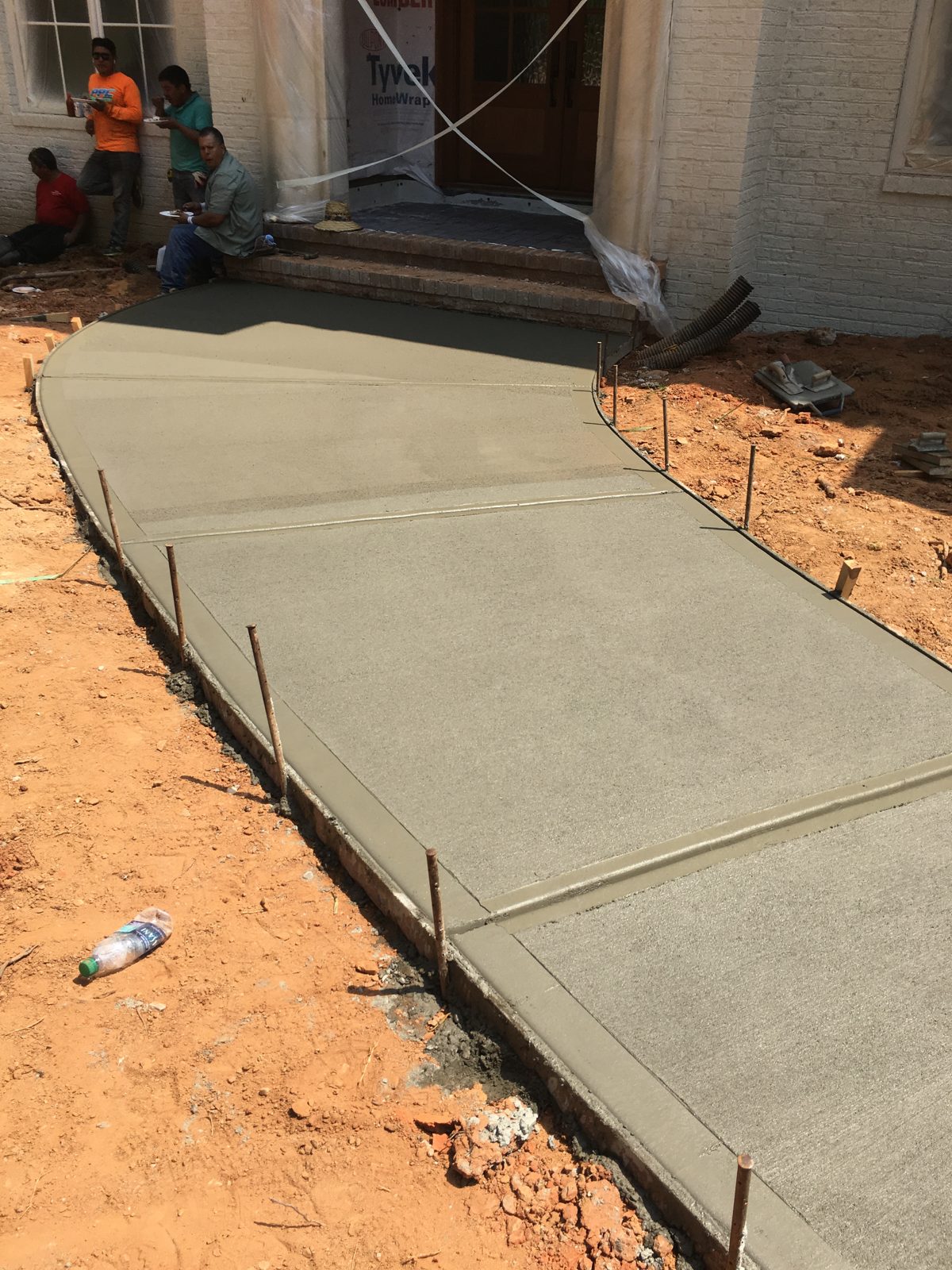 Finished concrete entry walkway leading toward a home's porch