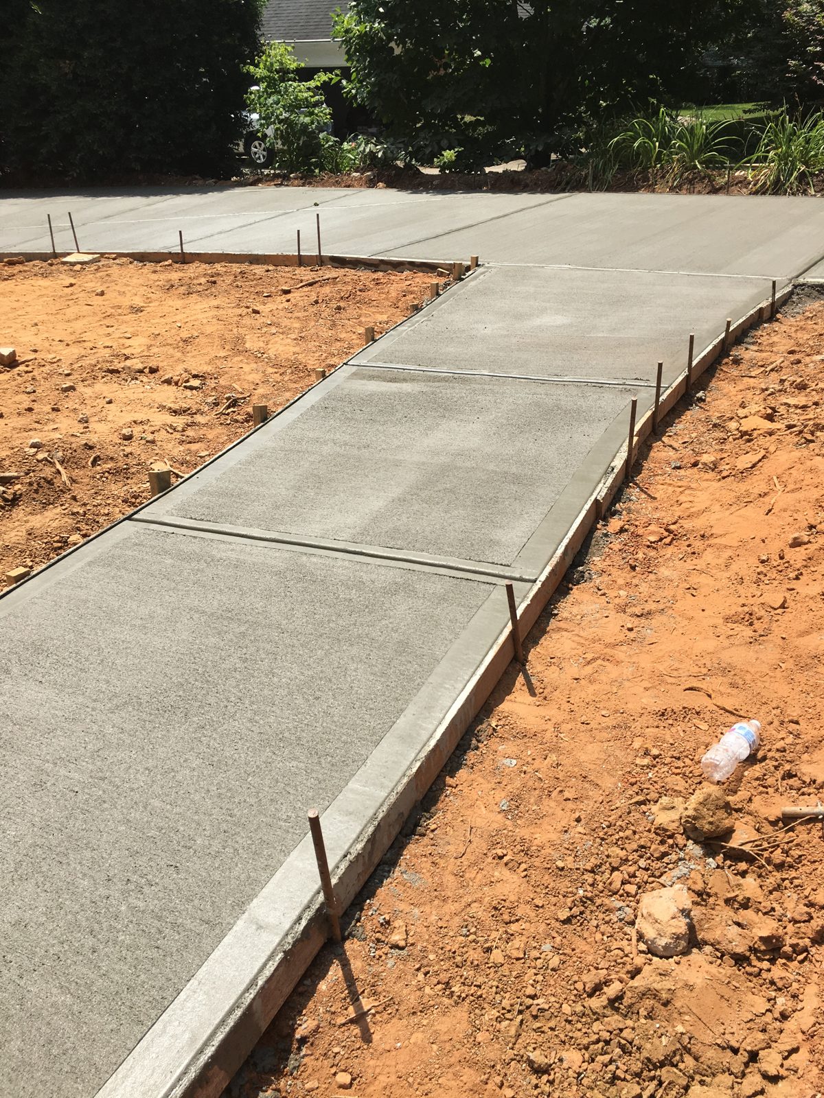 New concrete walkway meeting a residential driveway