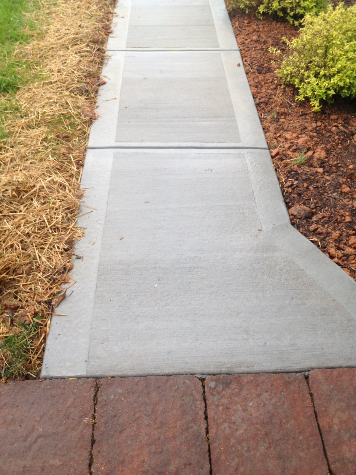 Finished residential concrete walkway beside a home