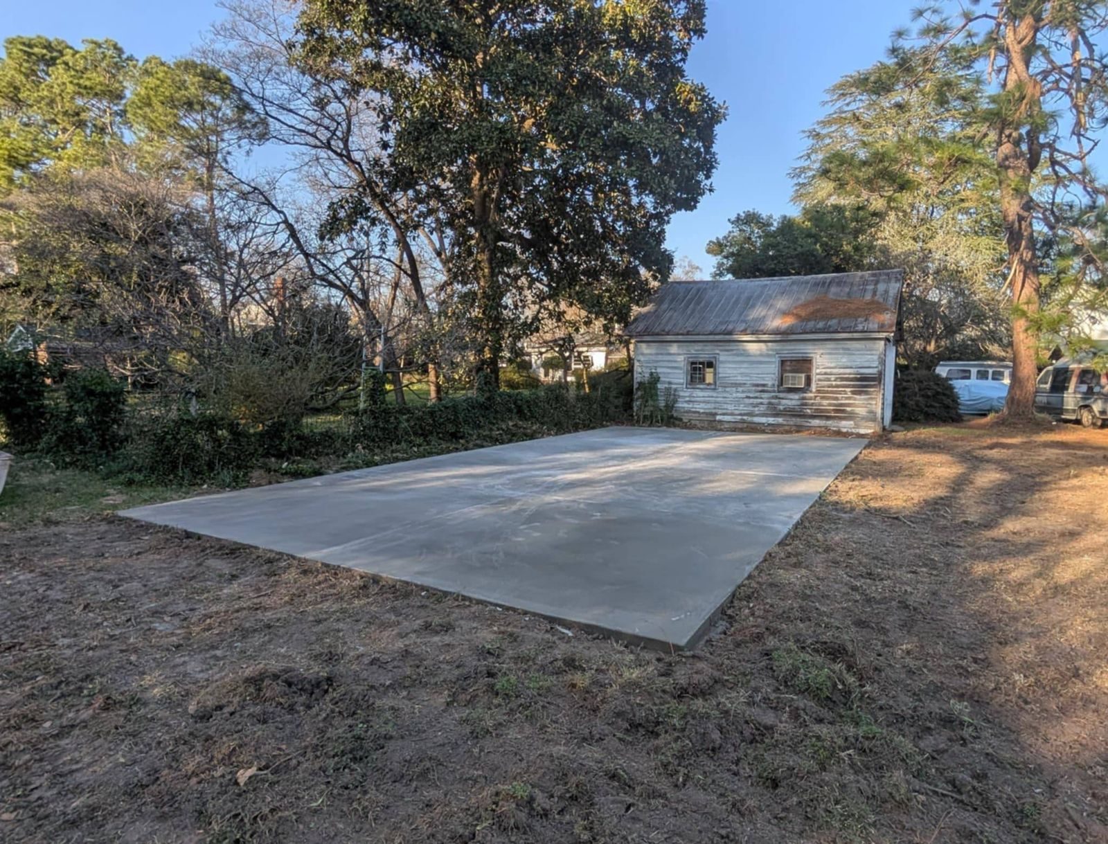 Finished concrete slab beside a detached garage
