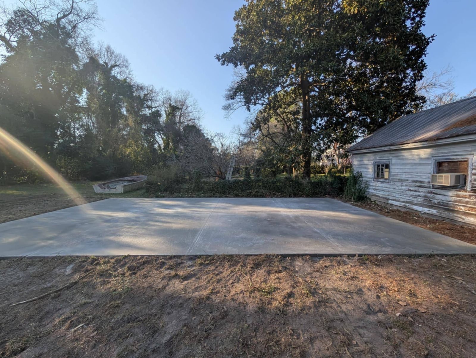 New concrete slab beside a garage and yard
