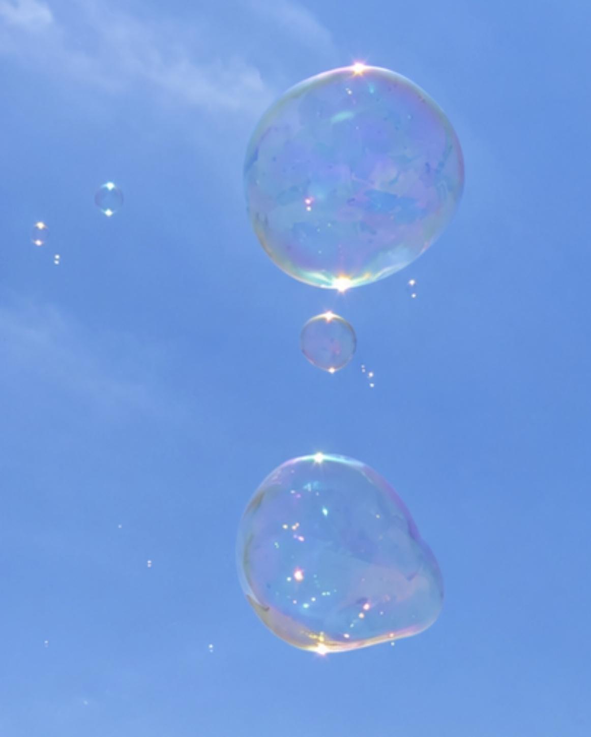 Iridescent soap bubbles floating against a blue sky