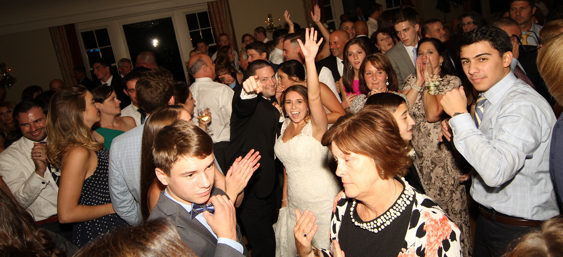 Wedding guests celebrating together on a packed dance floor