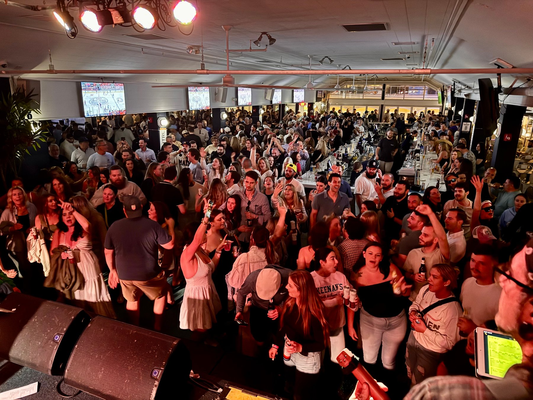 Guests singing and raising their hands in front of the stage