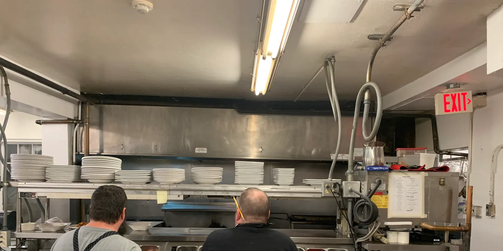 Restaurant team preparing a commercial kitchen service station before opening