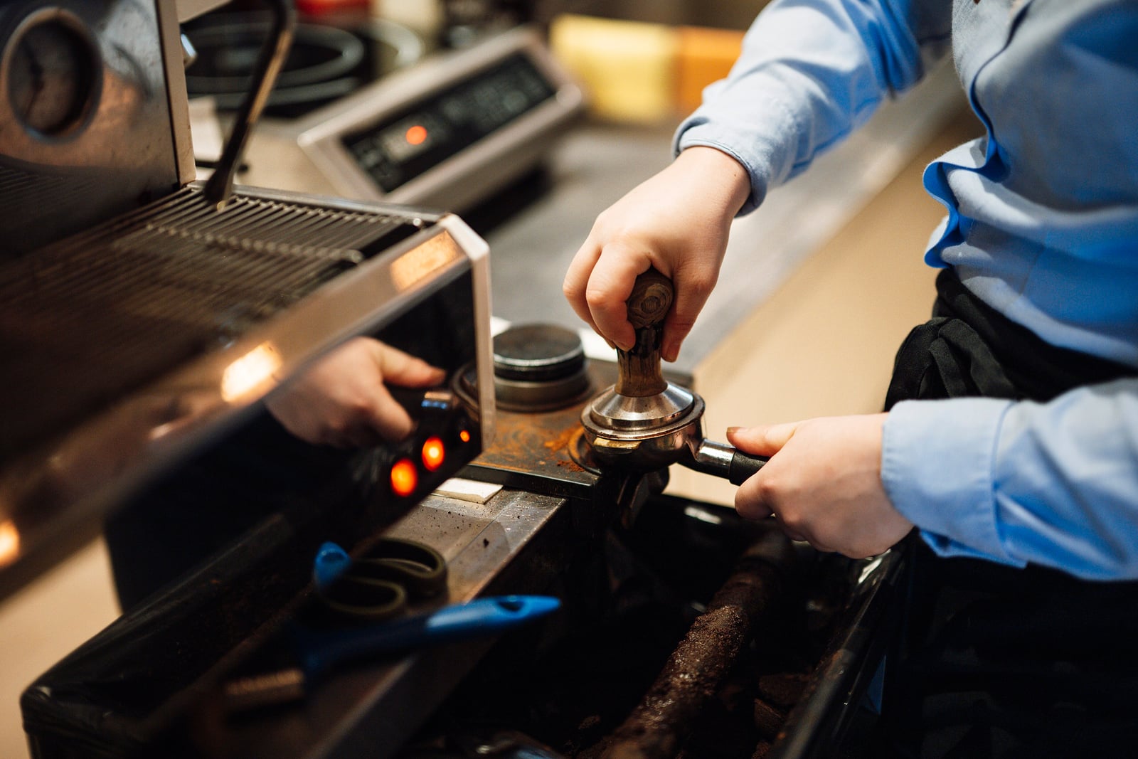 Barista preparing espresso at a coffee shop counter