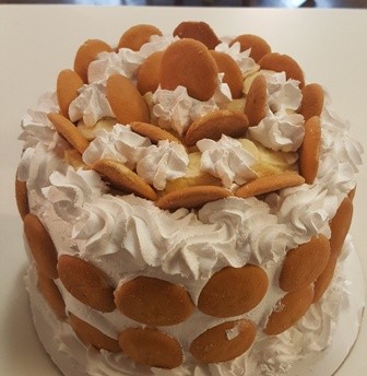 Celebration cake covered with cream swirls and vanilla wafer cookies