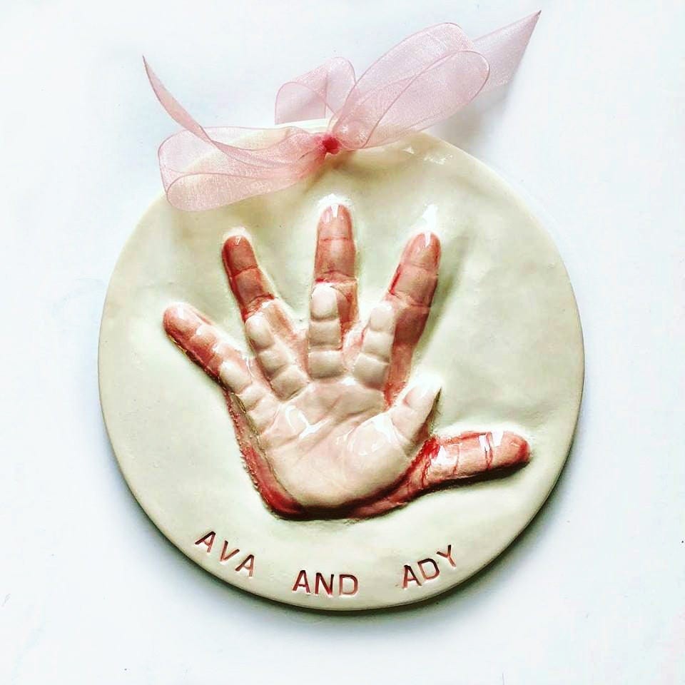 A ceramic handprint keepsake shown with its detail.