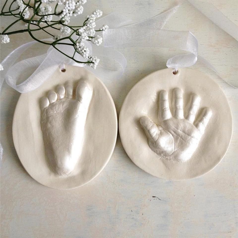 A handmade ceramic baby handprint keepsake ornament.