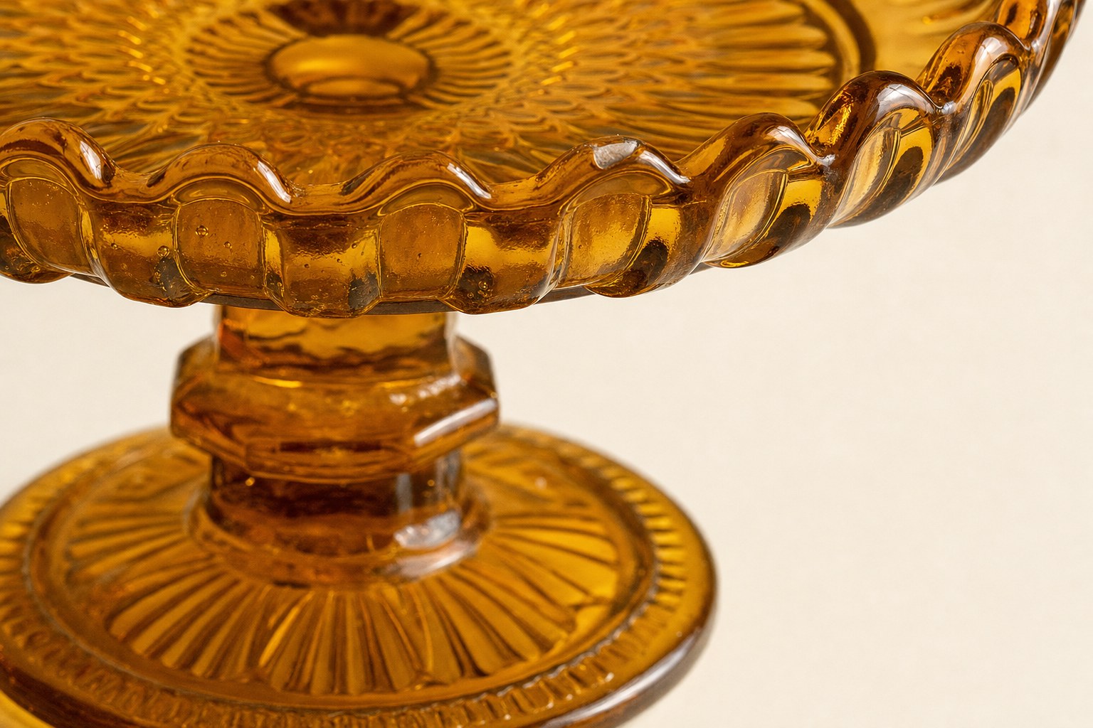 Close inspection view of the rim and foot of an amber pressed glass pedestal dish