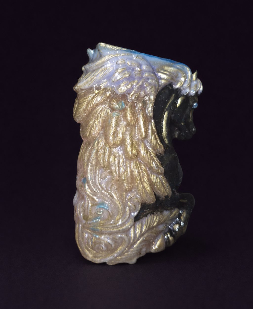 Side view of the resin Pegasus showing its detailed gold-accented wing