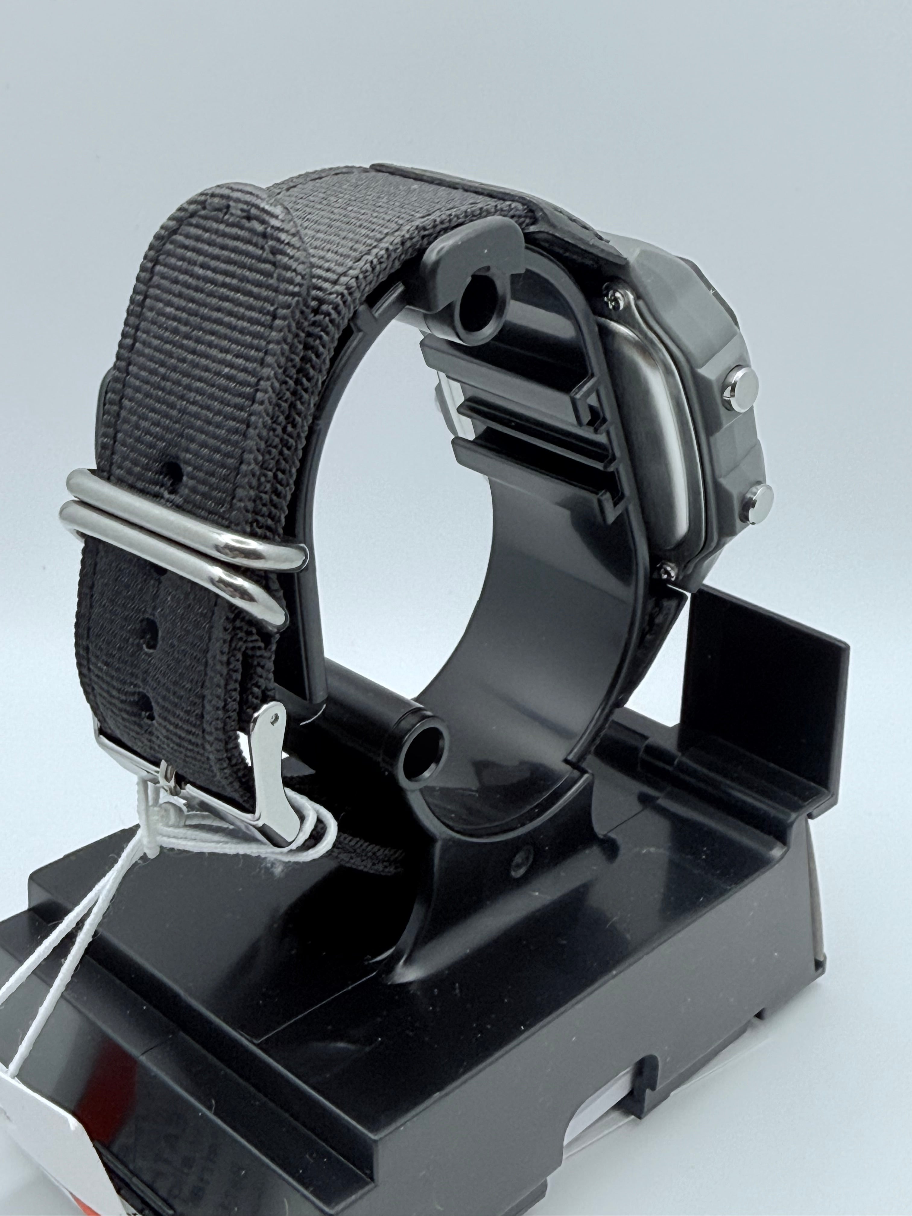 Rear view of the Casio AE1200 on its fabric strap and presentation stand