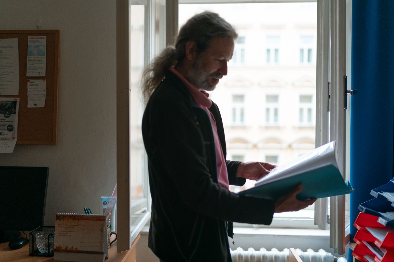 Person reviewing a folder of important documents by a window