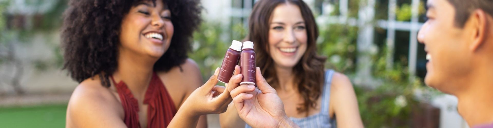 Friends sharing E+ adaptogen-powered energy shots