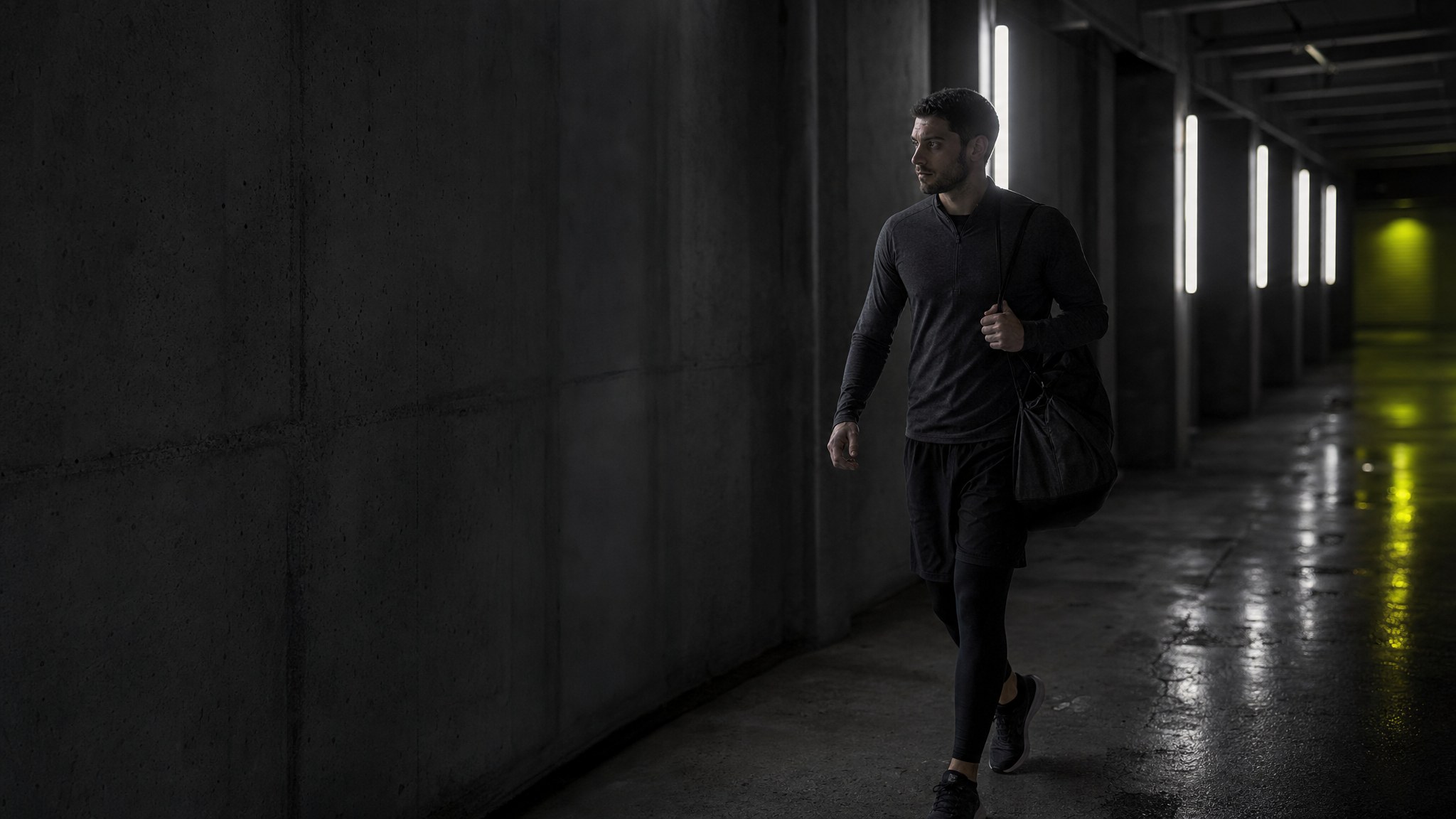 Athlete walking through a dimly lit training corridor