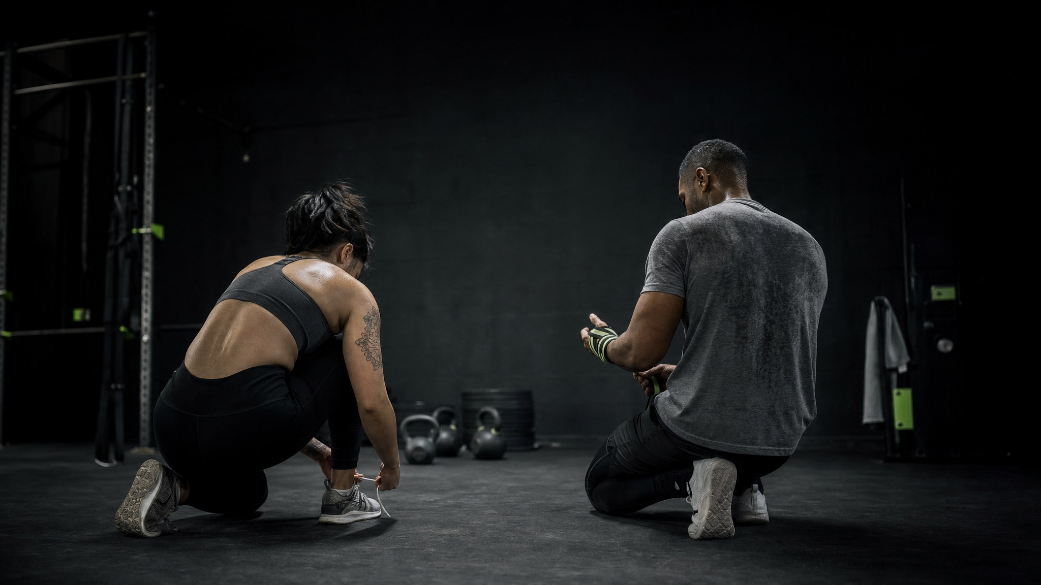 Two athletes preparing for training in a dark gym