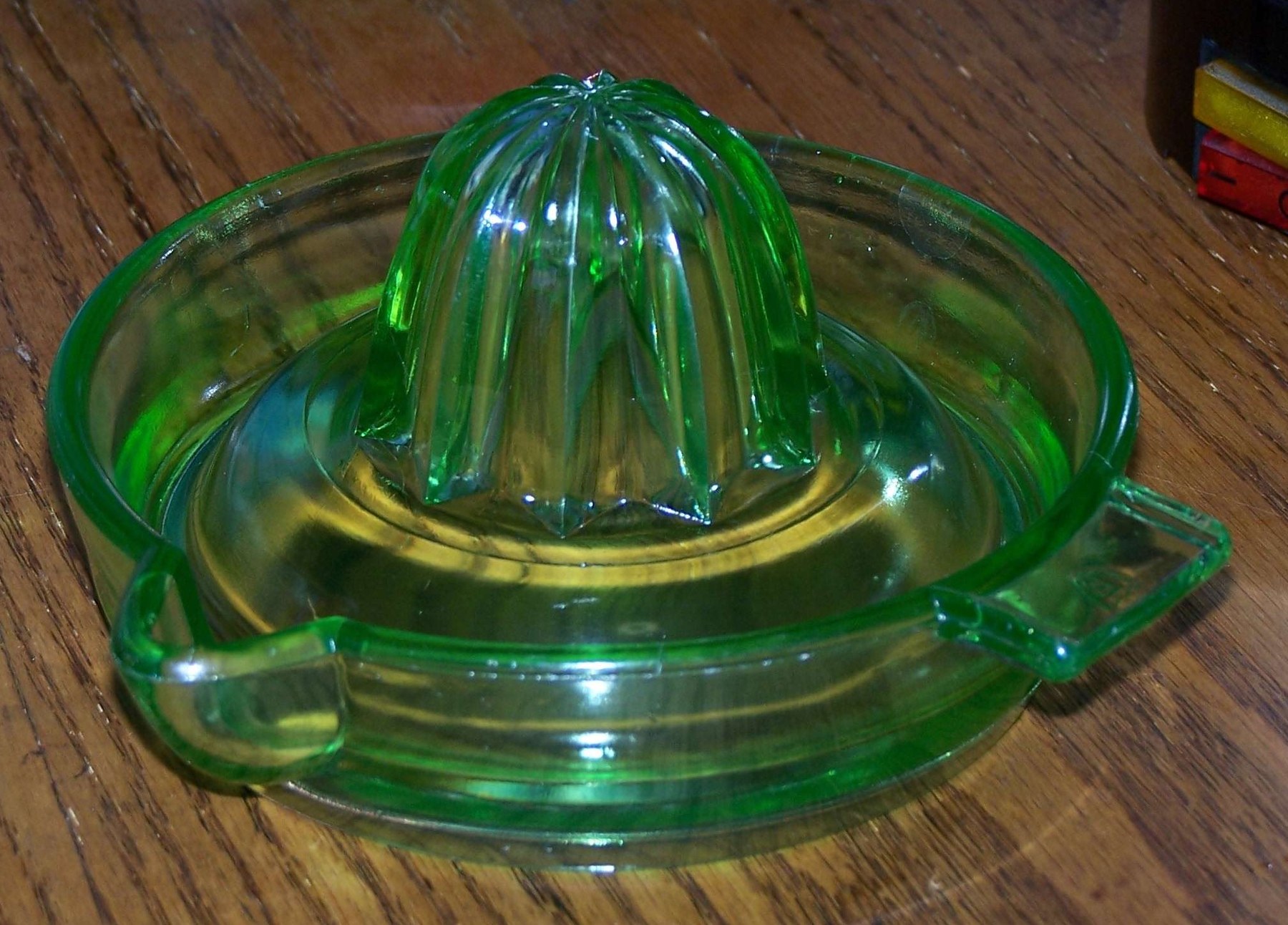 A pale green Depression glass juicer with a raised pattern