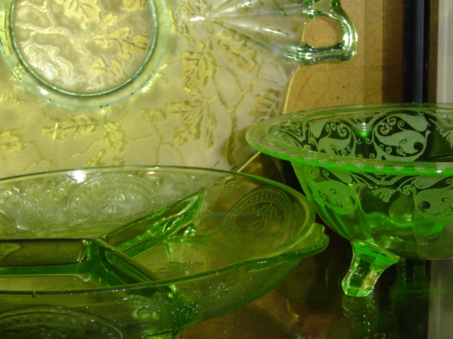 Green pressed glassware with a repeating molded pattern