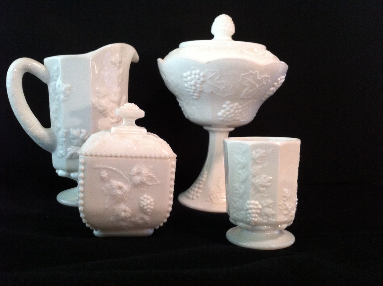 Four white milk glass pieces showing different shapes and raised patterns