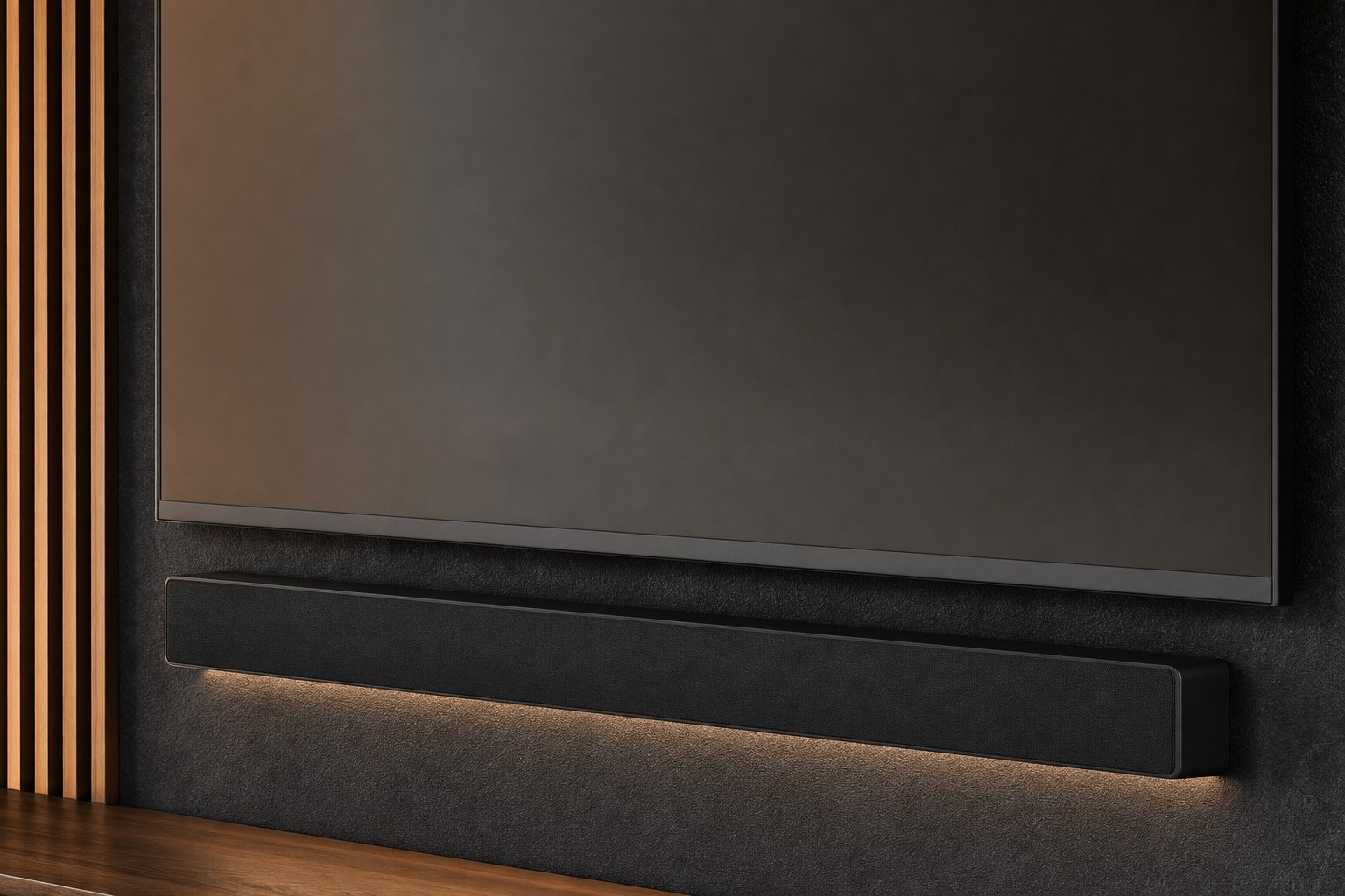 Close detail of a television and soundbar aligned on a charcoal wall