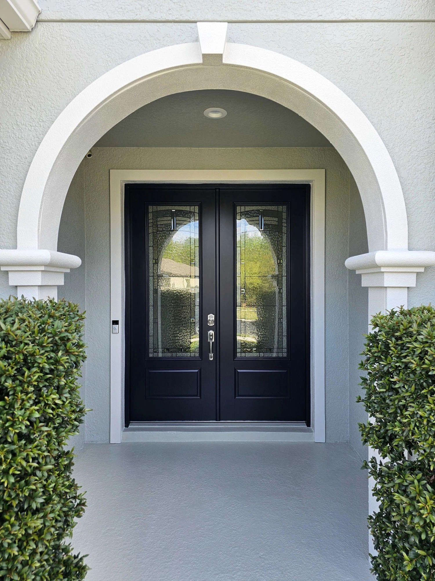 Freshly painted arched entrance with dark double doors