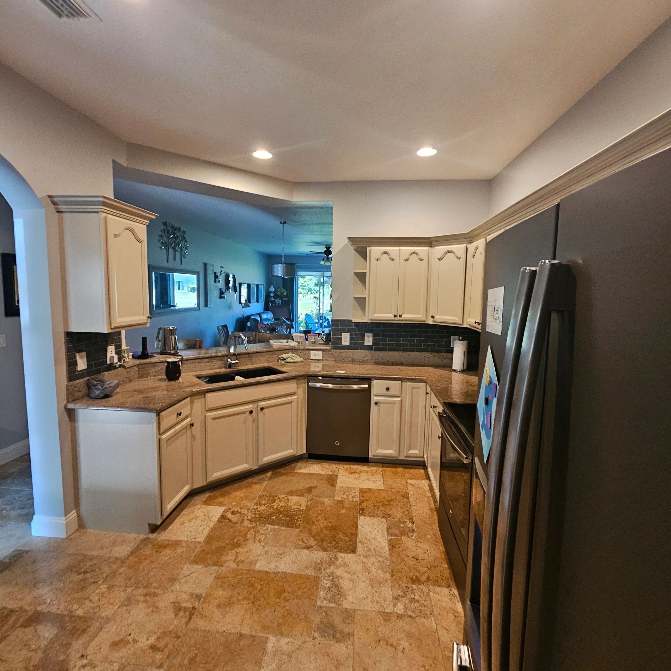 Full kitchen with freshly painted cabinets around the sink and cooking area
