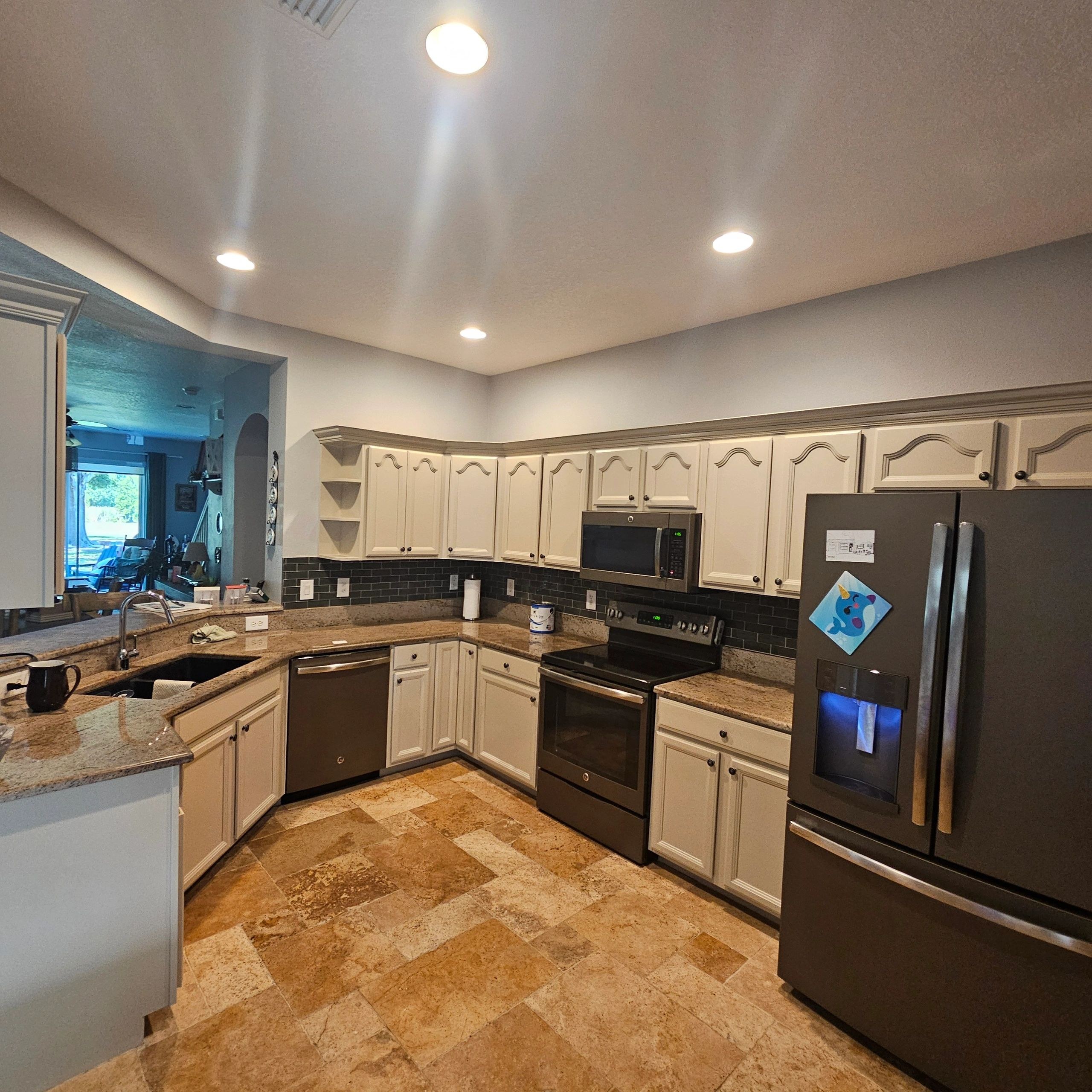 Wide kitchen view showing freshly painted upper and lower cabinets