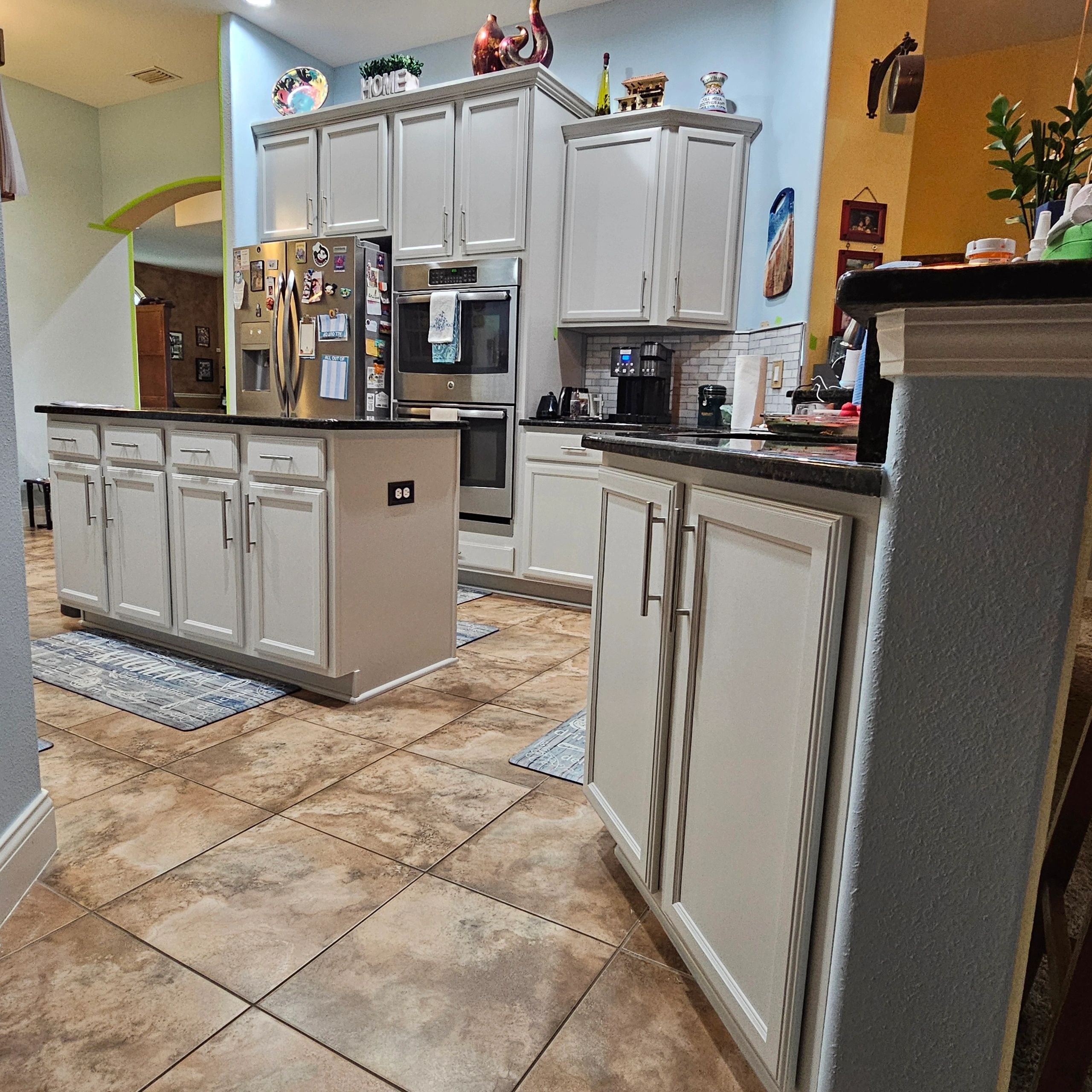Freshly painted kitchen cabinets around a refrigerator