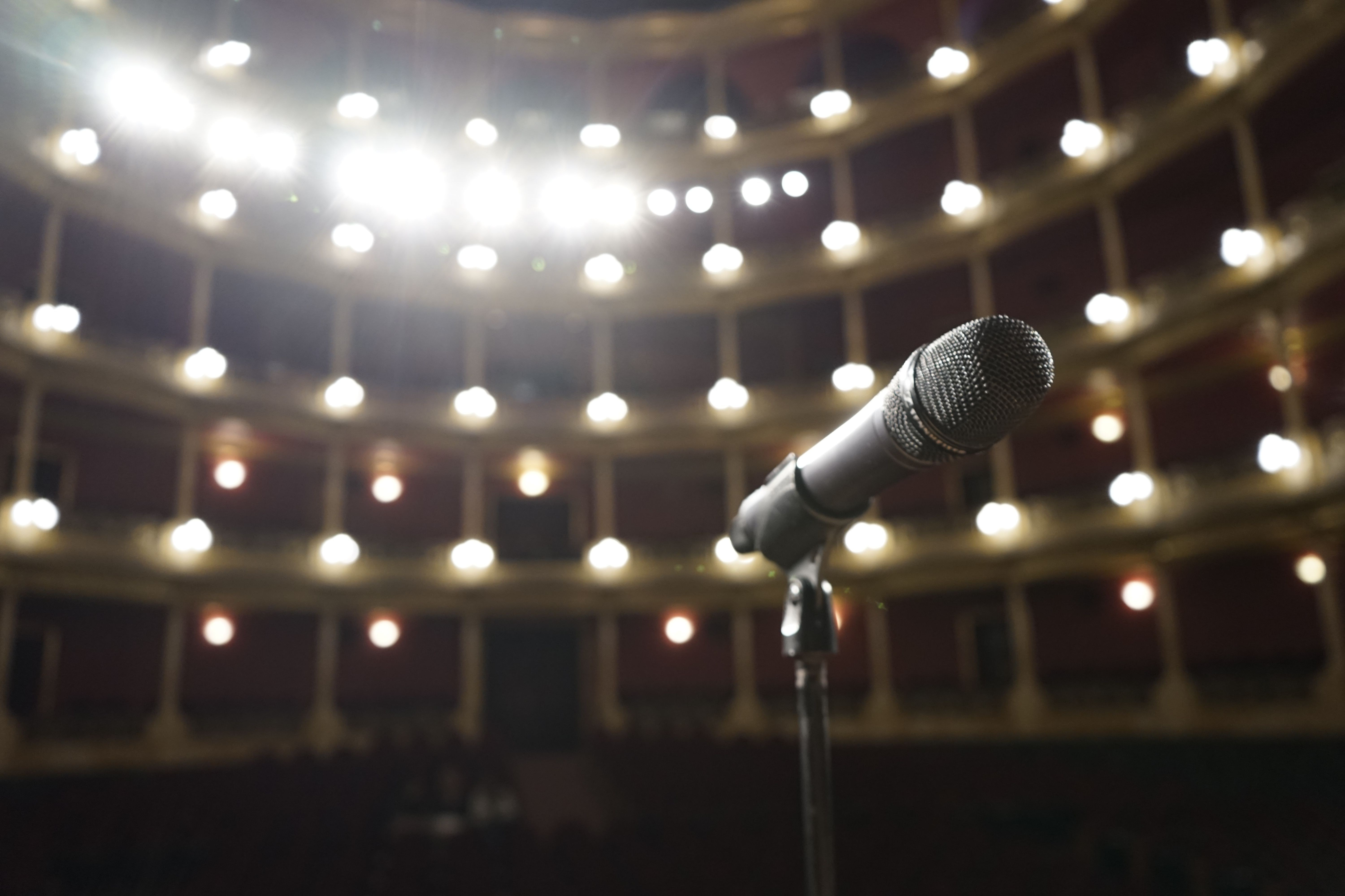 Microphone on a stand with auditorium lights in the background