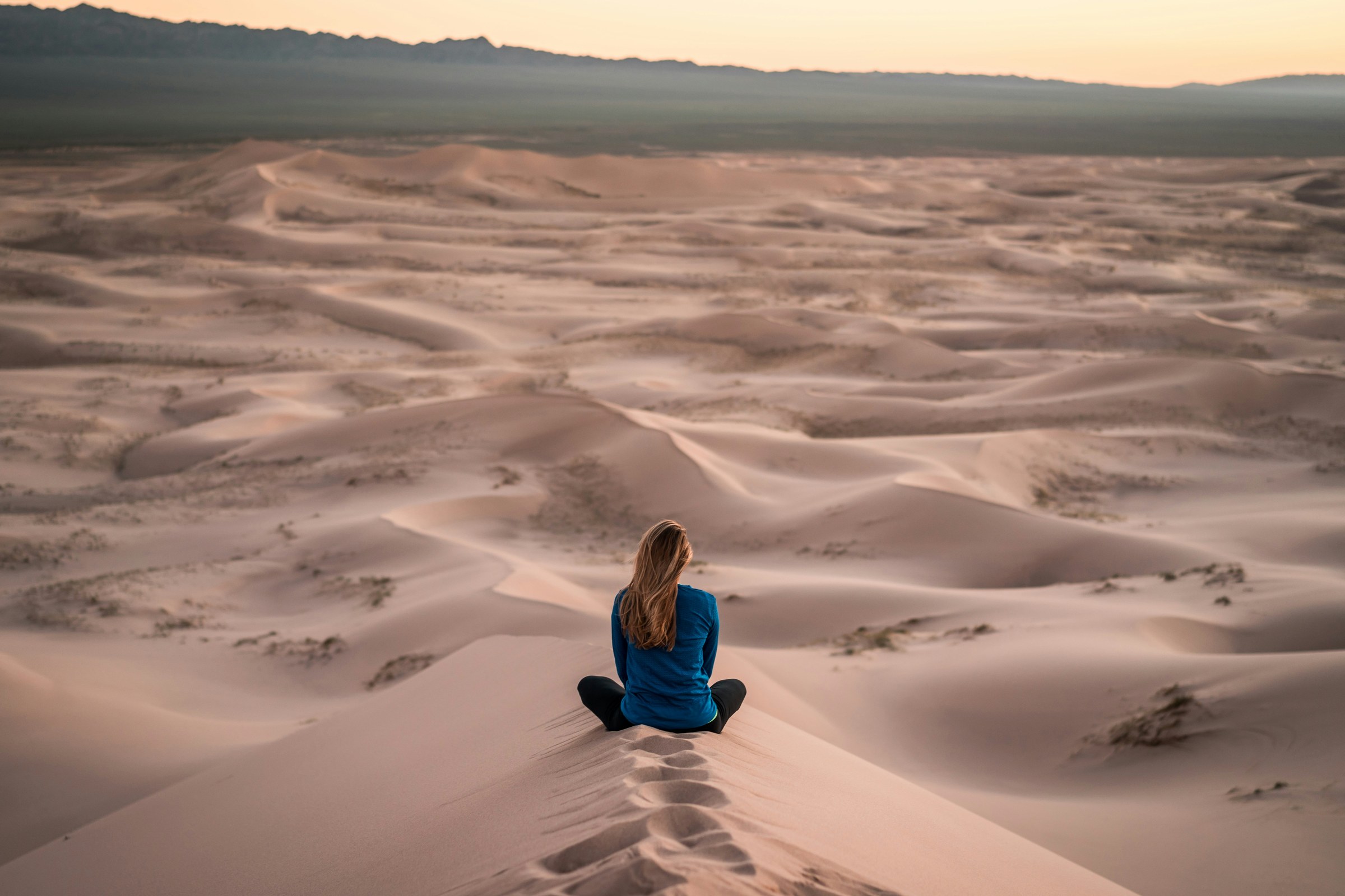 Person pausing quietly in an open landscape