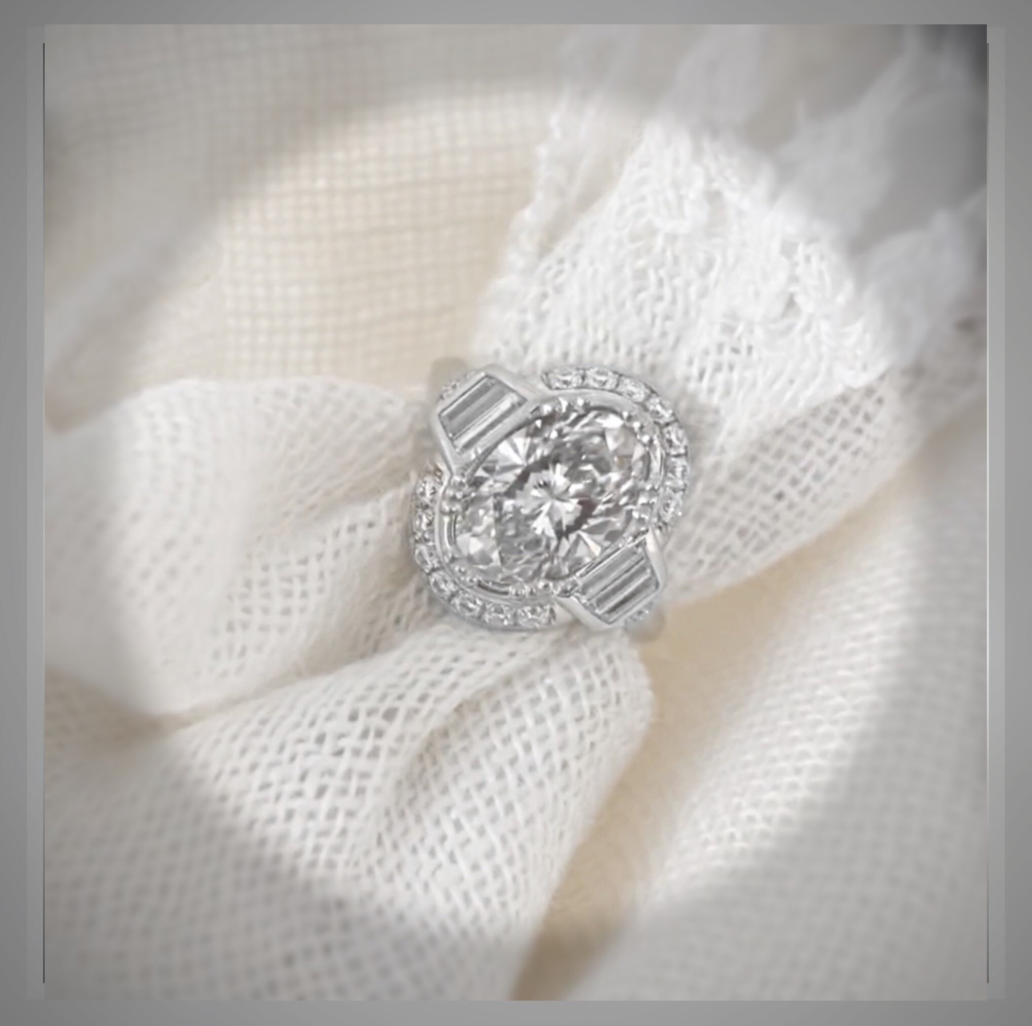 Art Deco-inspired oval diamond engagement ring with a geometric halo