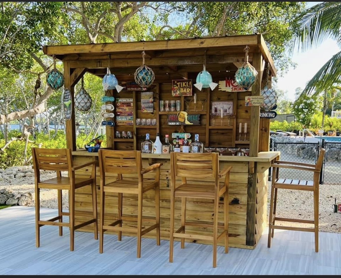 Tropical backyard bar with stools near the water