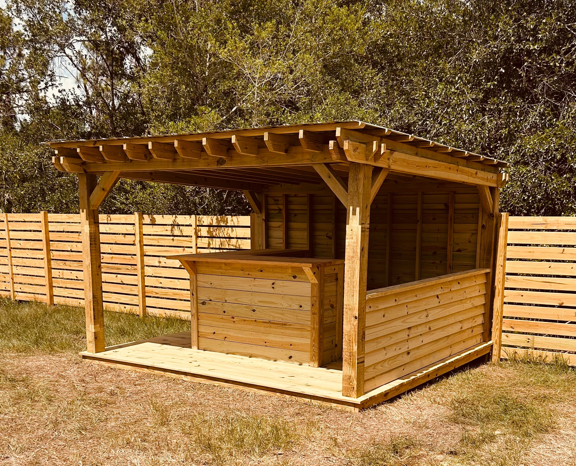 Custom wood grill hut with a covered roof, bar counter, and side walls