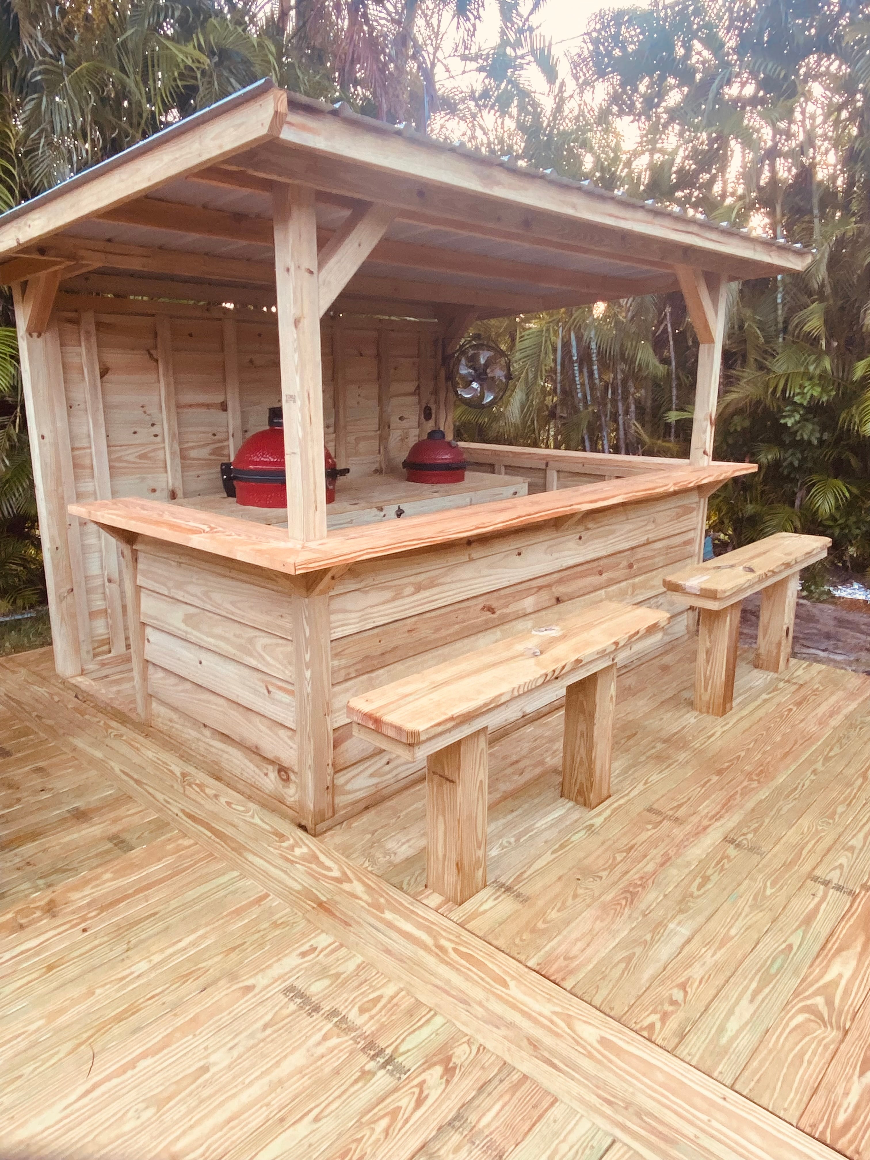 Custom wood grill hut with bar counter, benches, and ceramic grills