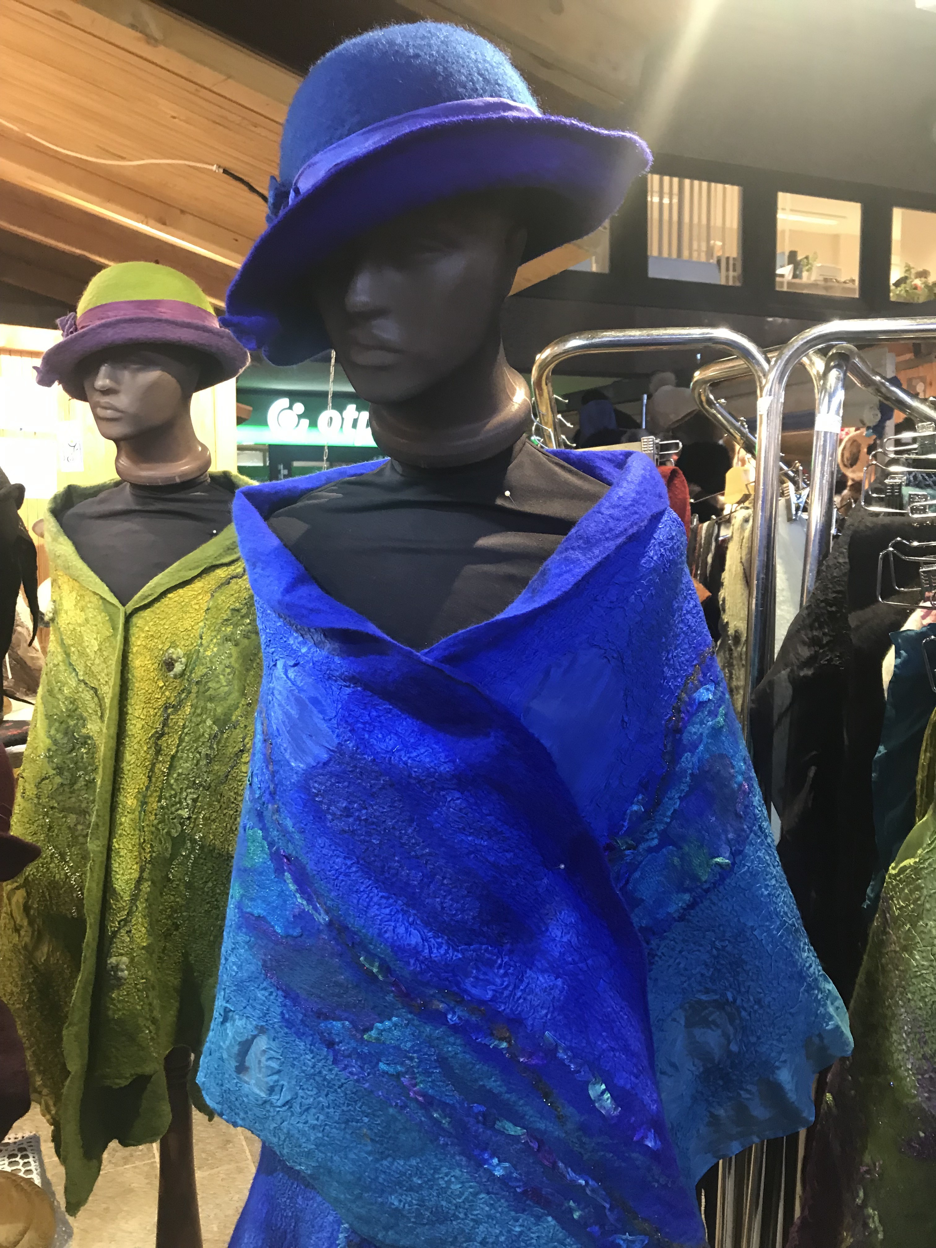 Blue and green felt outfits displayed on mannequins in Budapest