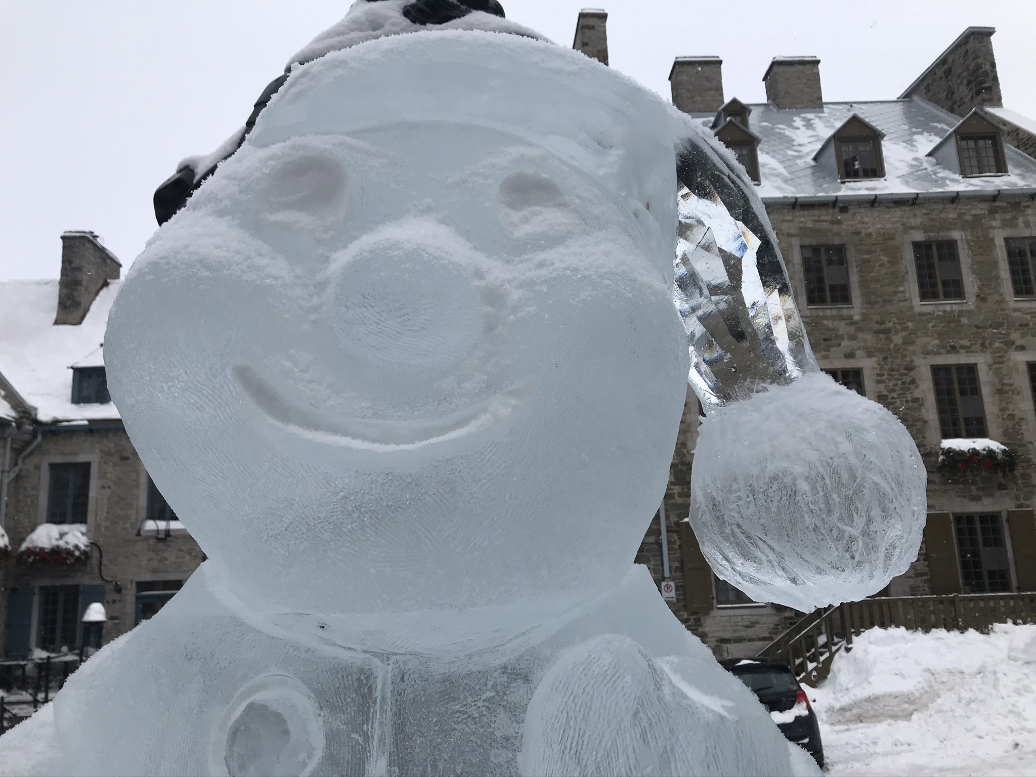 An ice sculpture with a stocking cap in snowy Old Quebec