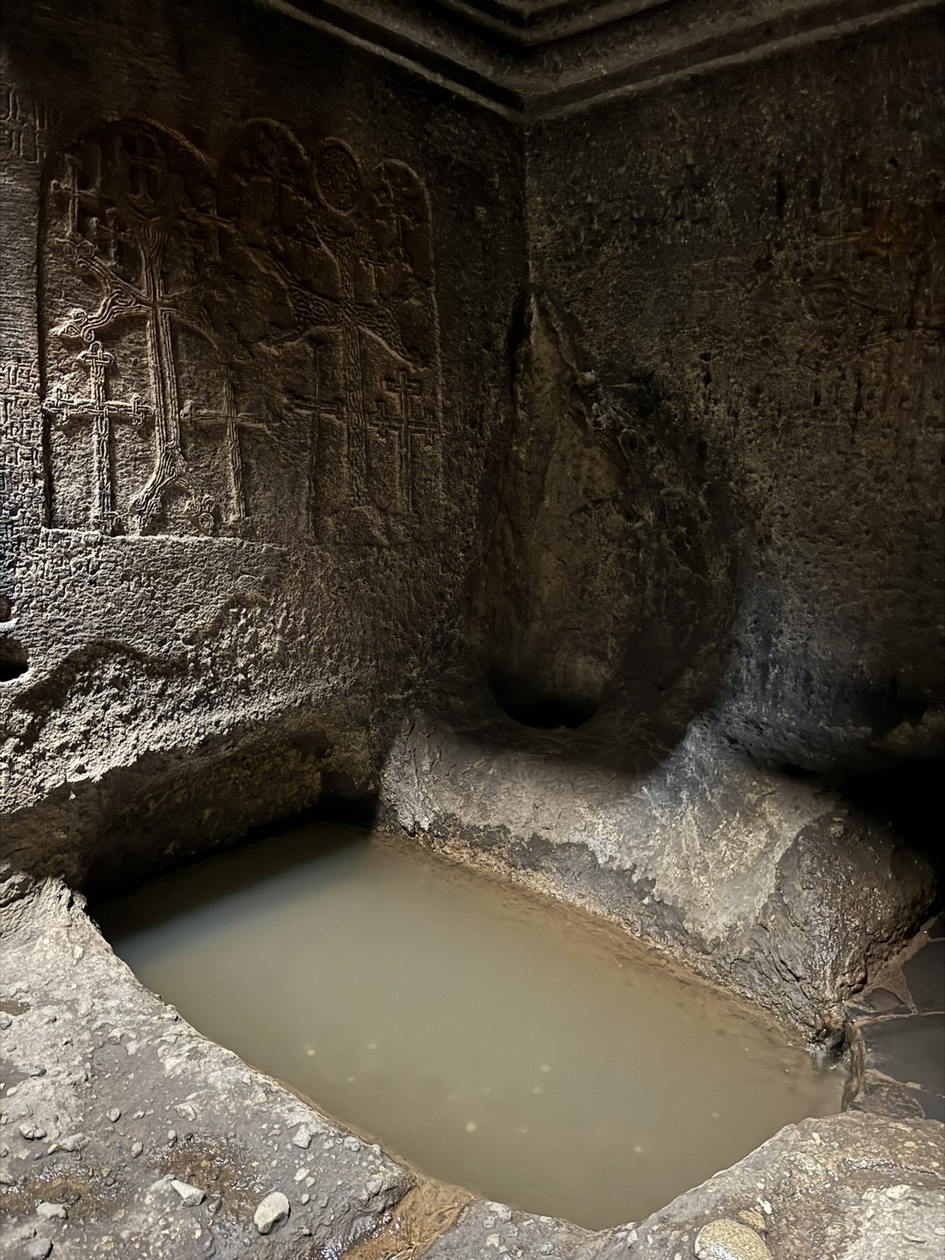 A stone basin of spring water inside Geghard Monastery.