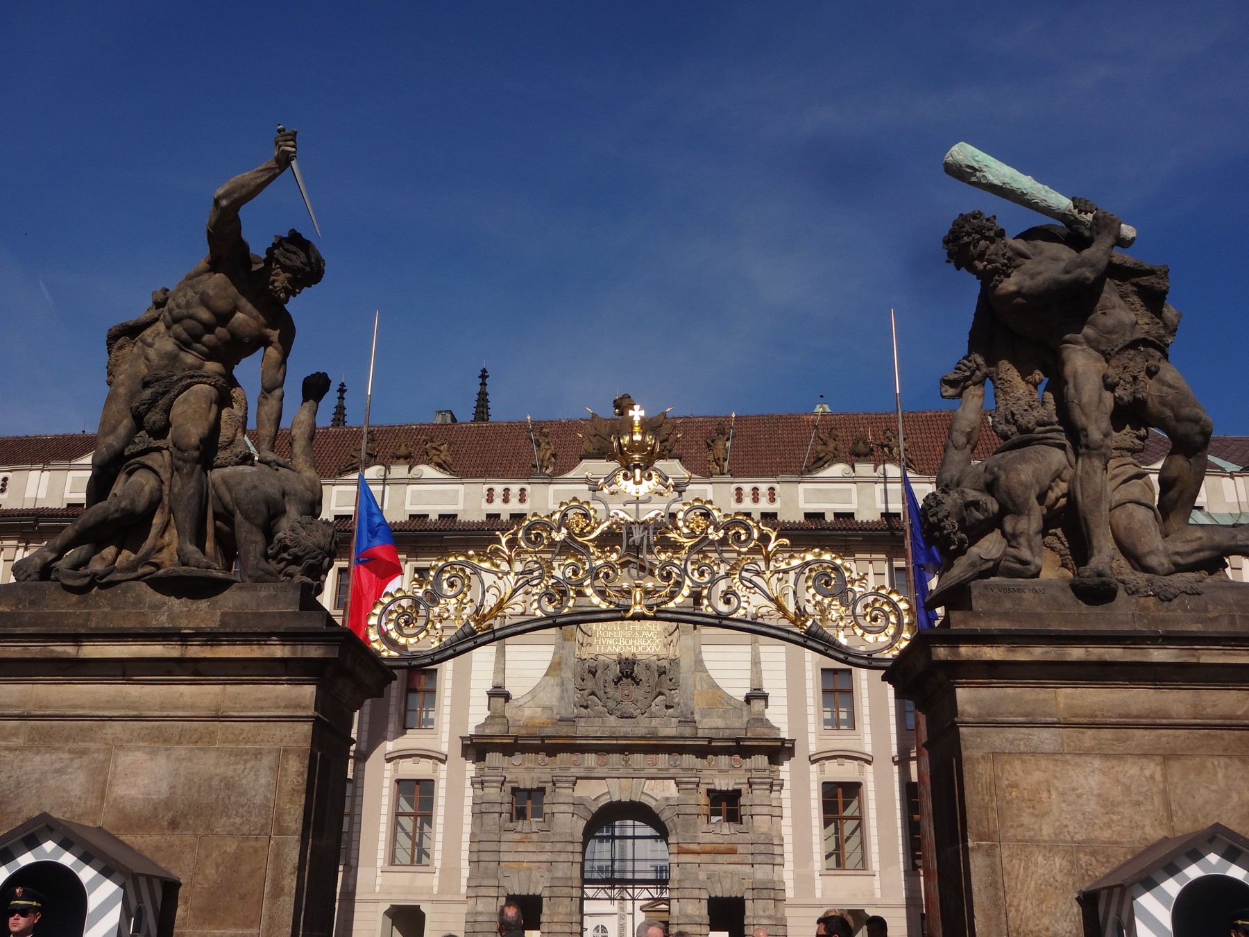 Sculpted giants above the ornate entrance gate to Prague Castle.