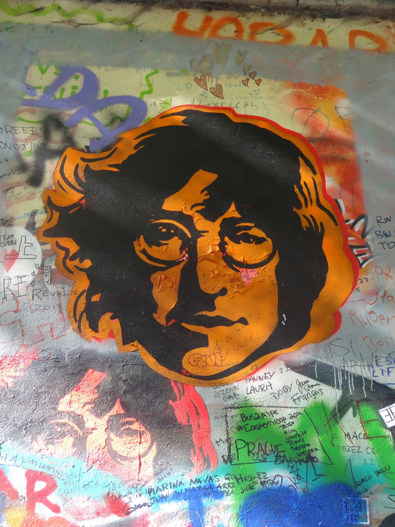 A portrait of John Lennon on the colorful Lennon Wall in Prague.