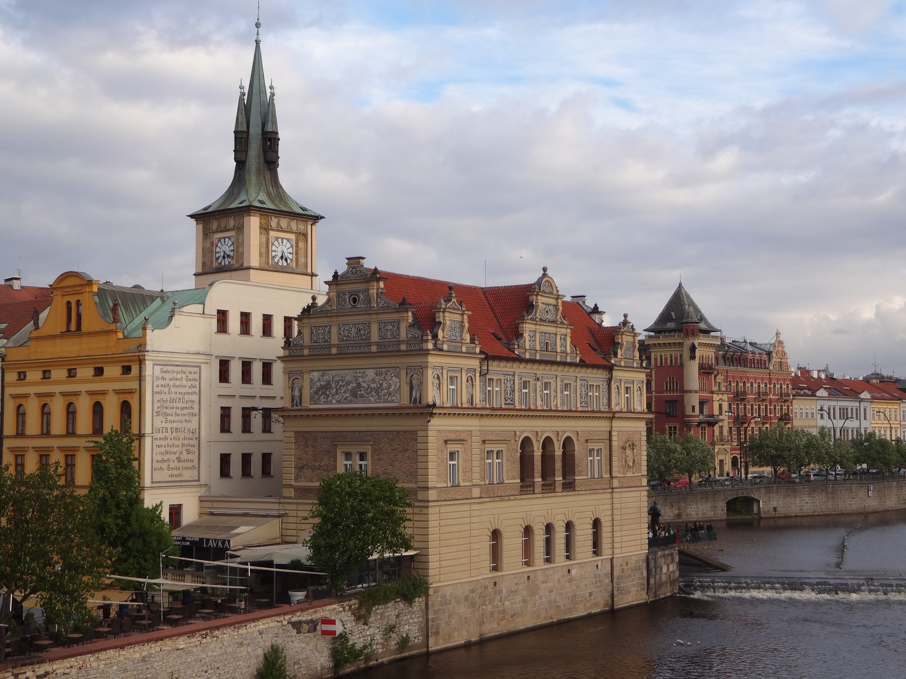 Historic buildings and a tower beside the Vltava in Prague.